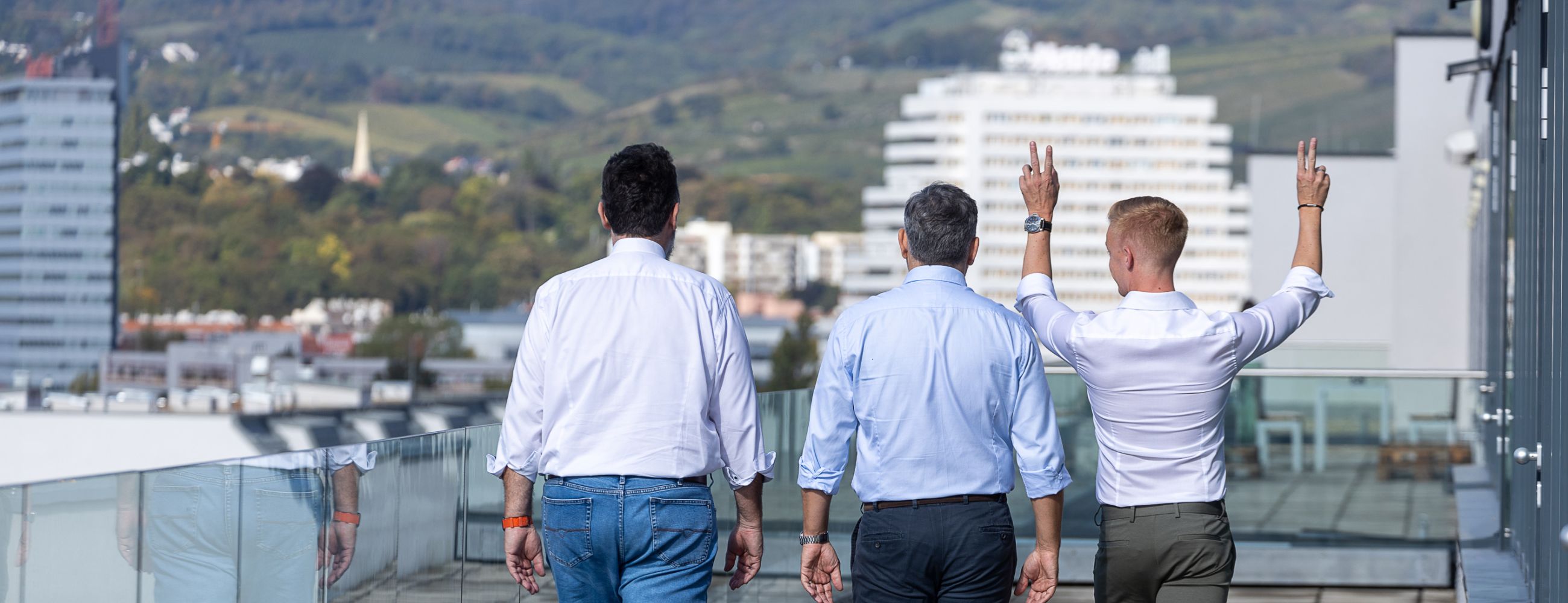 Das Team auf einer Terrasse mit dem Rücken zu uns